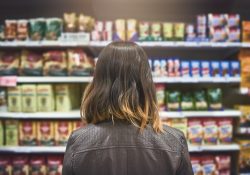 immagine ragazza che guarda scaffale di un supermercato GDO