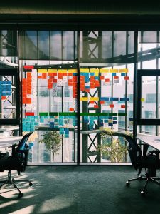 Ufficio smart con pareti a vetro, sedie di design e scrivanie con post it per organizzare lavoro